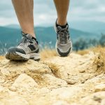 Coureur pratiquant le trail sur un sentier rocailleux en montagne avec des baskets Columbia Vertisol.